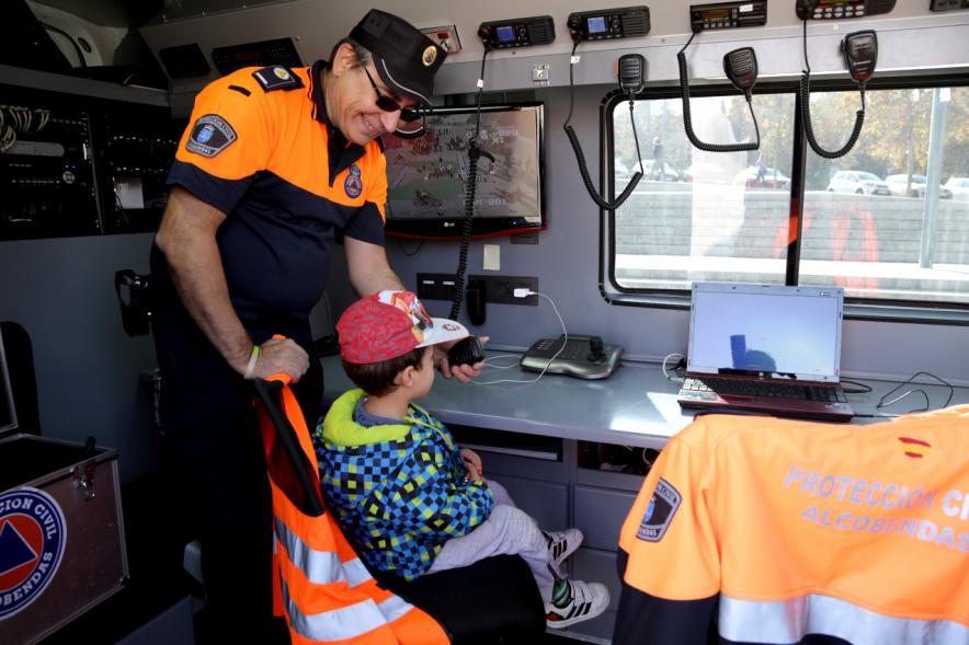 Jornada de Emergencias en Familia - Imagen de  miembros de cuerpos de seguridad mostrando una ambulancia al público asistente.