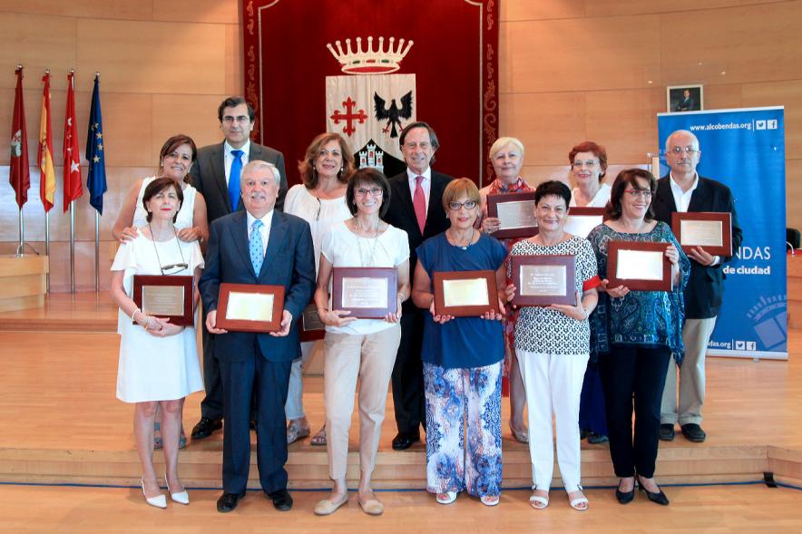 Acto de Jubilación de Profesores - Imagen del grupo de profesores en el escenario después he haber recibido su placa homenaje.