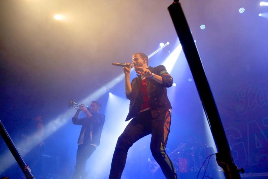 Cantante al micrófono bajo focos azulados
