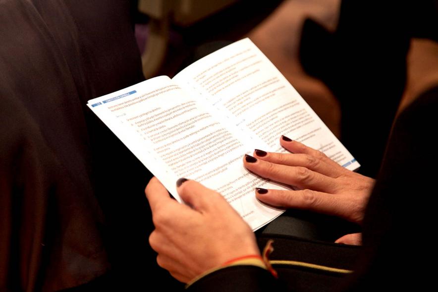 Lectura de la Constitución Española por su 40º Aniversario - Primer plano de  unas manos sujetando la Constitución.