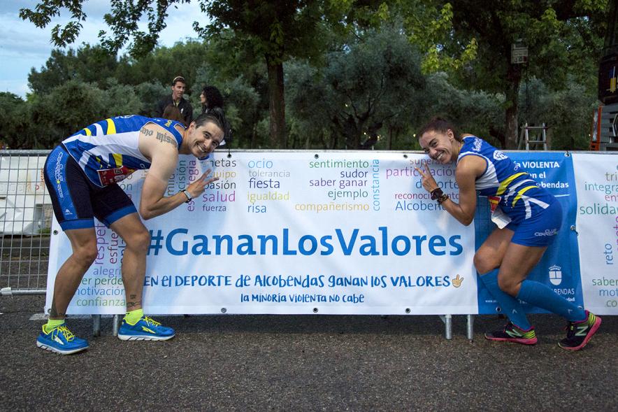 Legua Nocturna Zagros Sport -Posado de dos corredores delante del cartel promocional.