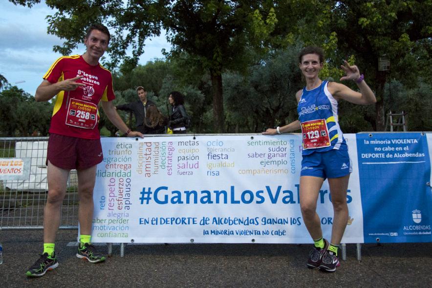 Legua Nocturna Zagros Sport - Posado de dos corredores delante del cartel promocional.