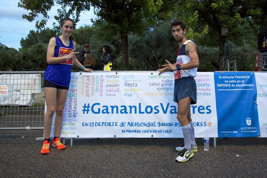 Legua Nocturna Zagros Sport - Posado de dos corredores delante del cartel promocional.