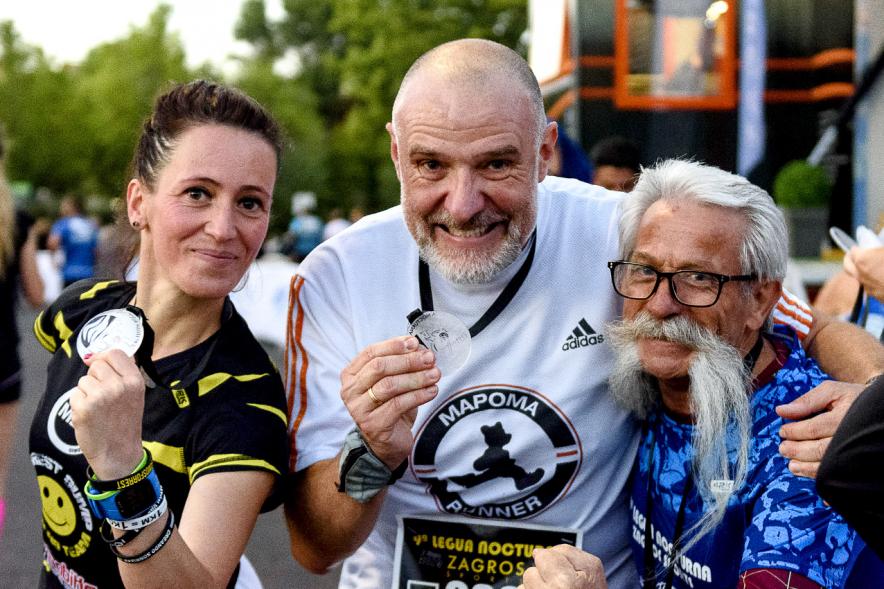 Legua Nocturna 2019 - Imagen de varios participantes de la carrera mostrando sus medallas.
