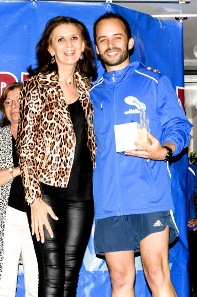 Legua Nocturna 2019 - Imagen de la concejal de deportes Mar Rodríguez posando junto a un participante de la carrera.