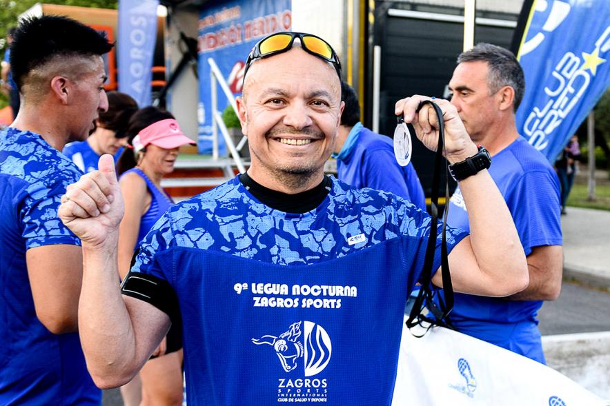 Legua Nocturna 2019 - Imagen de un participante de la carrera con su medalla.