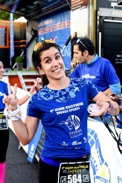 Legua Nocturna 2019 - Imagen de una participante de la carrera mostrando su medalla.