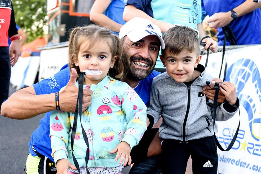 Legua Nocturna 2019 - Imagen de un participante posando con sus hijos.