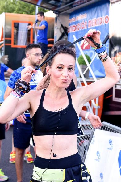 Legua Nocturna 2019 -  Imagen de una participante de la carrera mostrando su medalla.