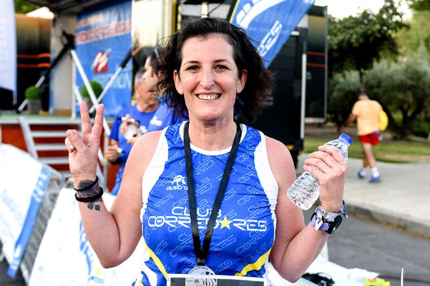 Legua Nocturna 2019 - Imagen de una participante de la carrera mostrando su medalla.