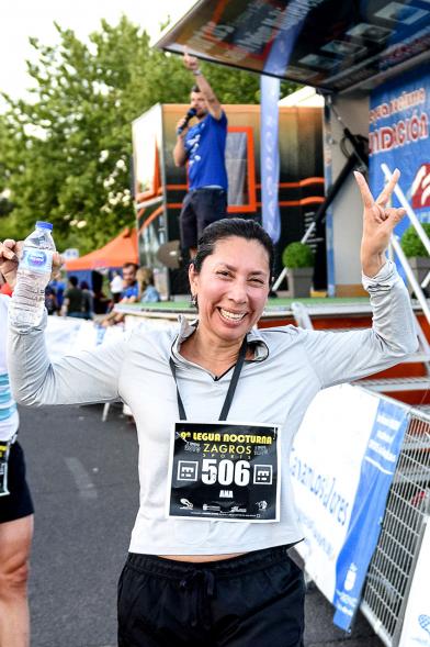 Legua Nocturna 2019 - Imagen de una participante de la carrera mostrando su medalla.