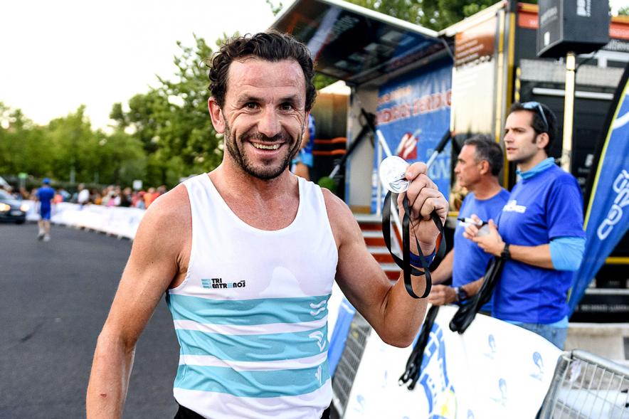 Legua Nocturna 2019 - Imagen de un participante de la carrera con su medalla.
