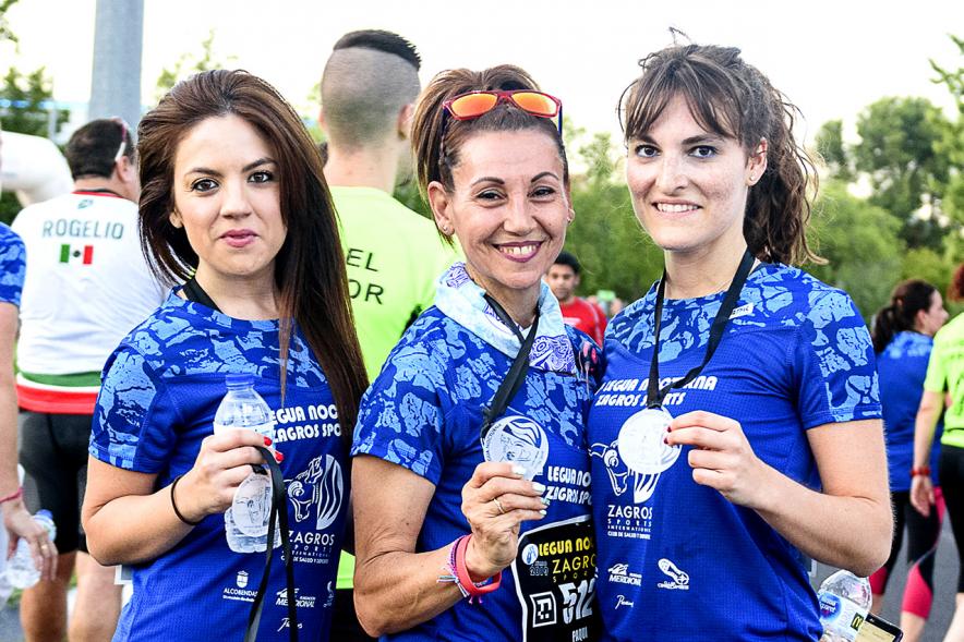 Legua Nocturna 2019 - Imagen de unas participantes de la carrera mostrando sus medallas.
