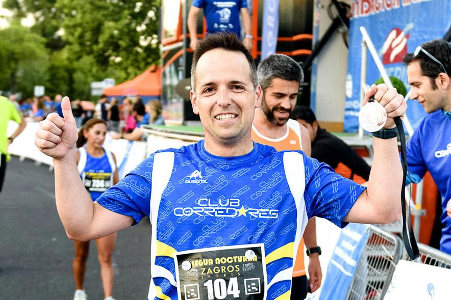 Legua Nocturna 2019 - Imagen de un participante de la carrera con su medalla.