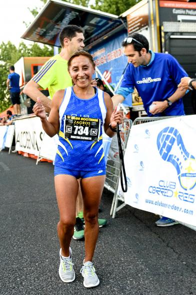 Legua Nocturna 2019 - Imagen de una participante de la carrera mostrando su medalla.