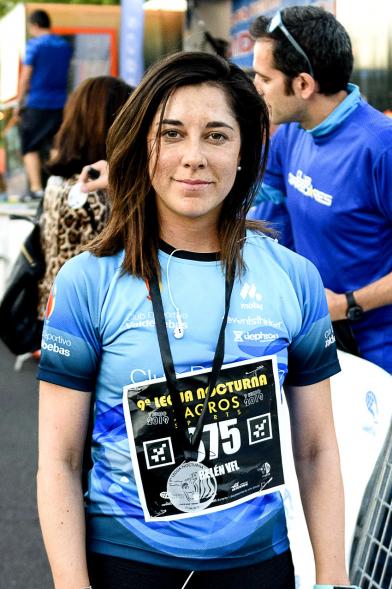 Legua Nocturna 2019 -  Imagen de una participante de la carrera mostrando su medalla.