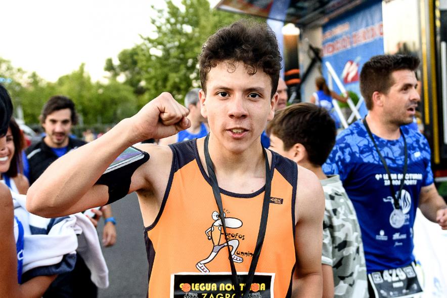 Legua Nocturna 2019 - Imagen de un participante de la carrera con su medalla.