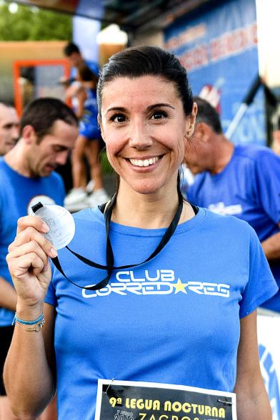 Legua Nocturna 2019 - Imagen de una participante de la carrera mostrando su medalla.