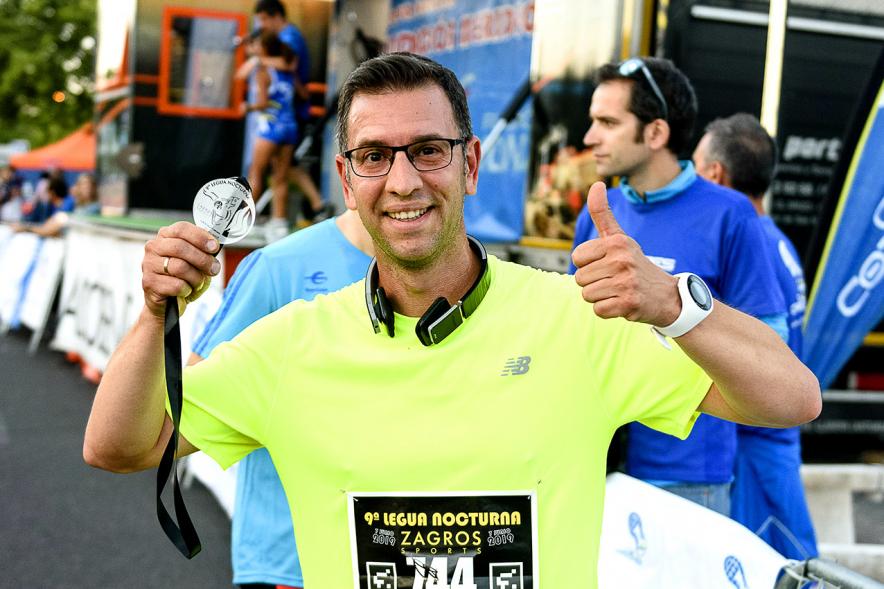 Legua Nocturna 2019 - Imagen de un participante de la carrera con su medalla.