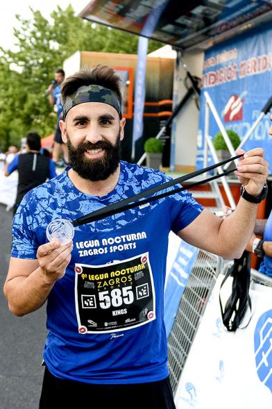 Legua Nocturna 2019 - Imagen de un participante de la carrera con su medalla.
