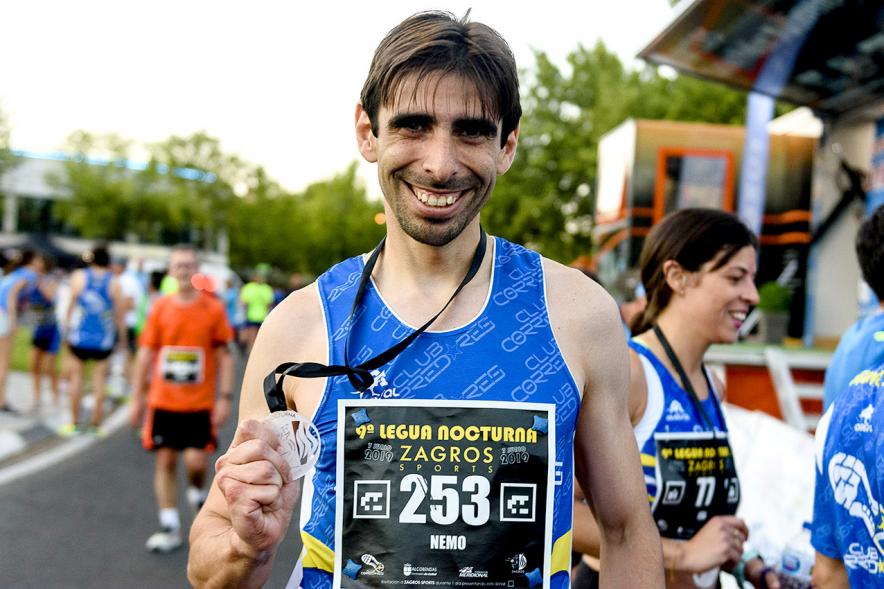 Legua Nocturna 2019 - Imagen de un participante de la carrera con su medalla.