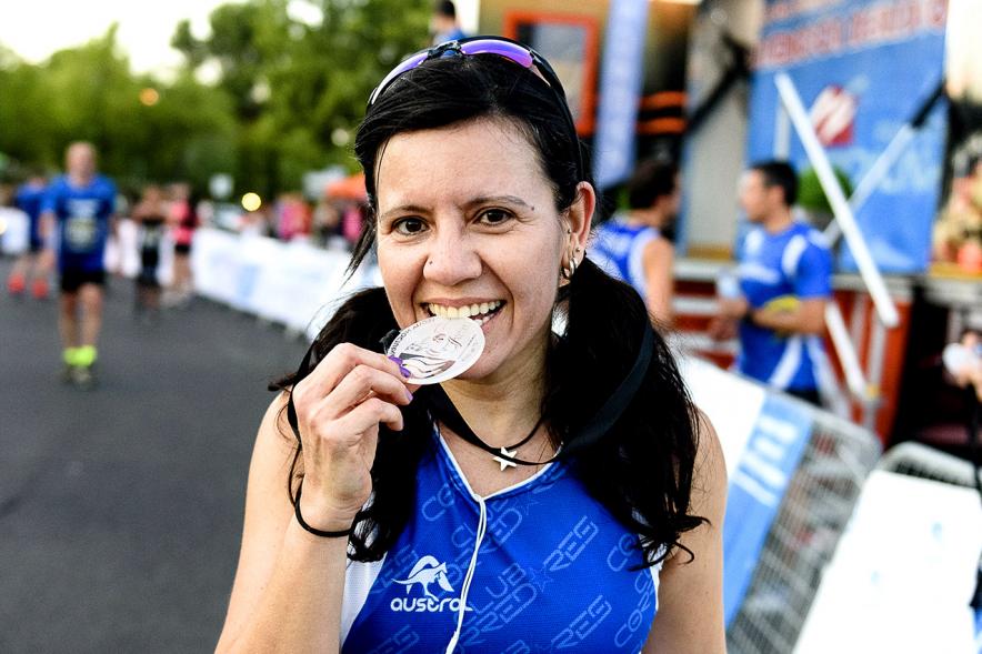 Legua Nocturna 2019 - Imagen de una participante de la carrera mostrando su medalla.