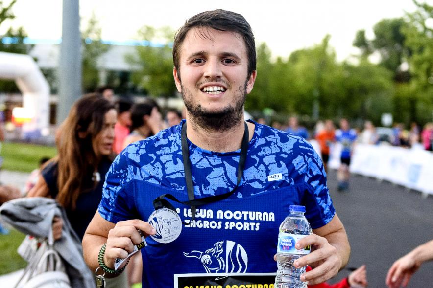 Legua Nocturna 2019 - Imagen de un participante de la carrera con su medalla.