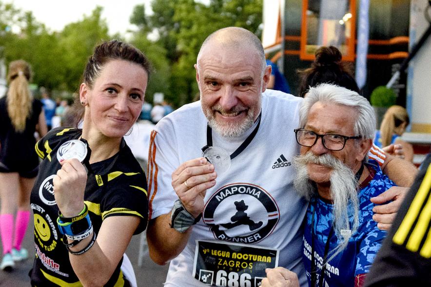 Legua Nocturna 2019 - Imagen de unas participantes de la carrera mostrando sus medallas.