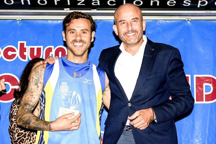 Legua Nocturna 2019 - Imagen de un corredor recibiendo su premio en el pódium.