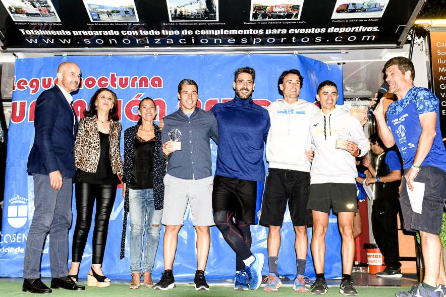 Legua Nocturna 2019 - Imagen de un corredor recibiendo su premio en el pódium.