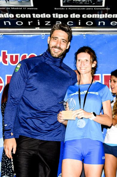 Legua Nocturna 2019 - Imagen de Jaime Nava, capitán de la Selección Española de Rugby en el pódium con una corredora después de haberla entregado su medalla.