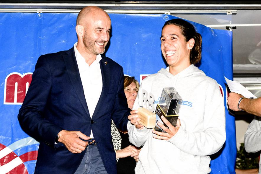 Legua Nocturna 2019 - Imagen de una corredora recibiendo su premio en el pódium.