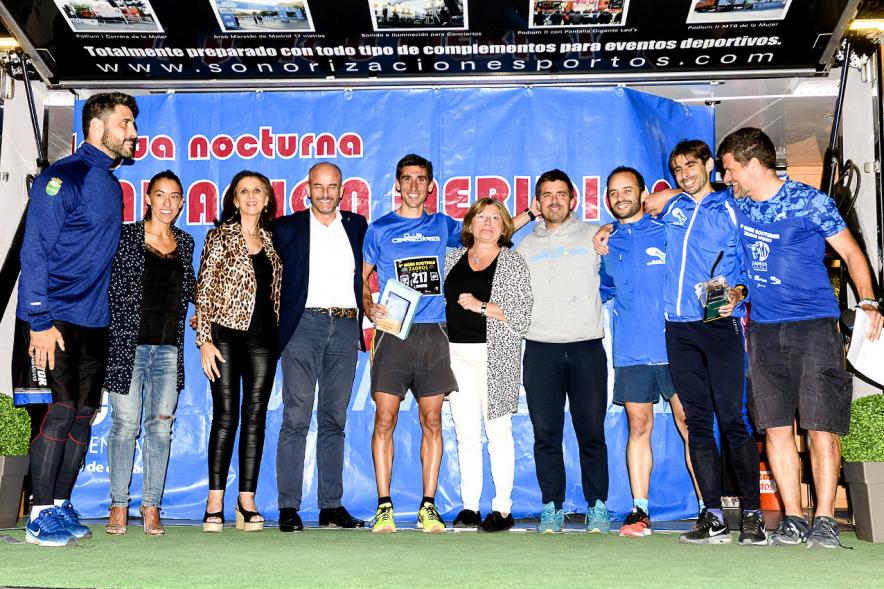 Legua Nocturna 2019 - Imagen de un corredor recibiendo su premio en el pódium.