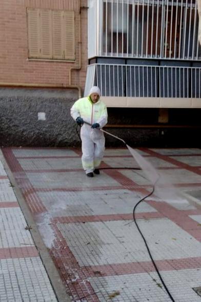 Operario con traje de protección desinfectando las calles durante el confinamiento