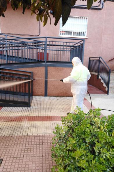 Operario con traje de protección desinfectando las calles durante el confinamiento