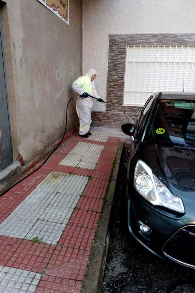 Operario con traje de protección desinfectando las calles durante el confinamiento