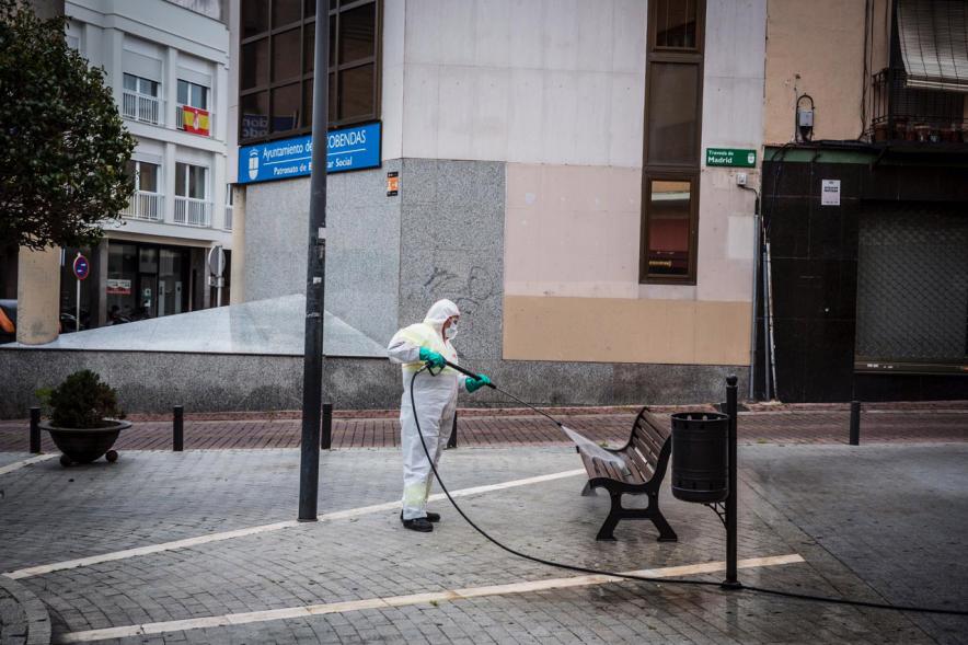 Operario con traje de protección desinfectando las calles durante el confinamiento