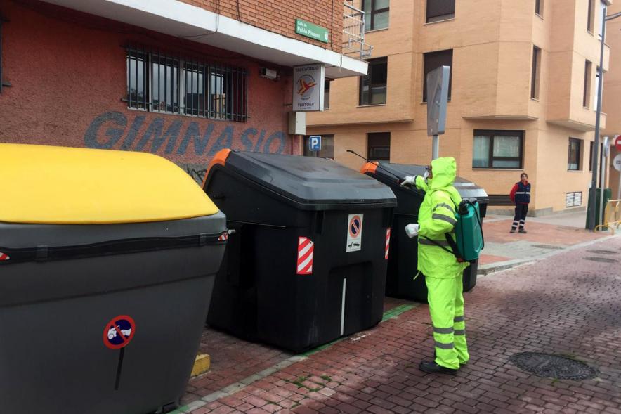 Operario con traje de protección desinfectando las calles durante el confinamiento