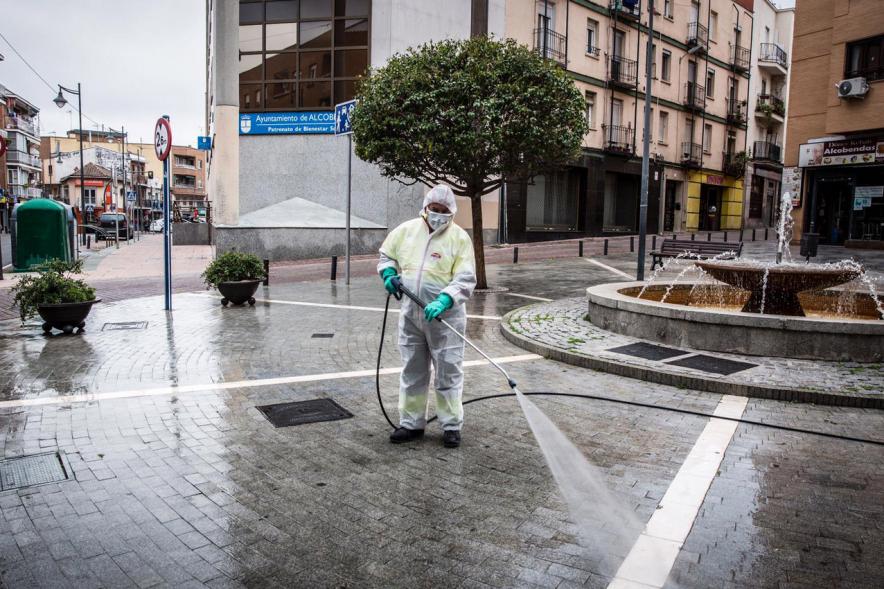 Operario con traje de protección desinfectando las calles durante el confinamiento