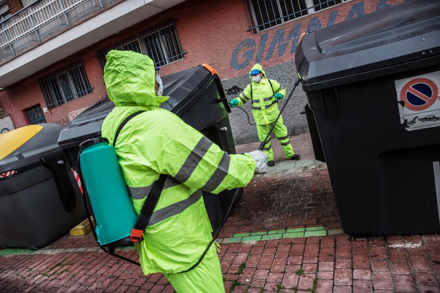 Operarios con traje de protección desinfectando las calles durante el confinamiento