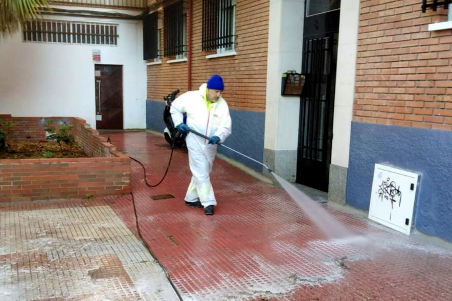 Operario con traje de protección desinfectando las calles durante el confinamiento