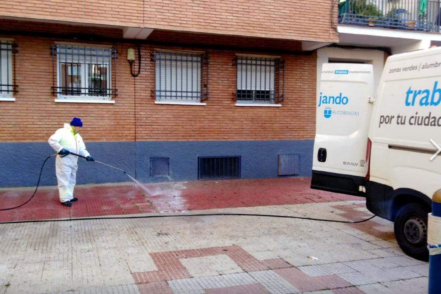 Operario con traje de protección desinfectando las calles durante el confinamiento