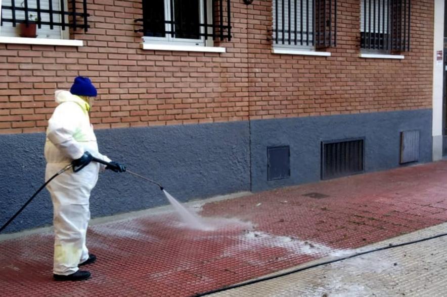 Operario con traje de protección desinfectando las calles durante el confinamiento