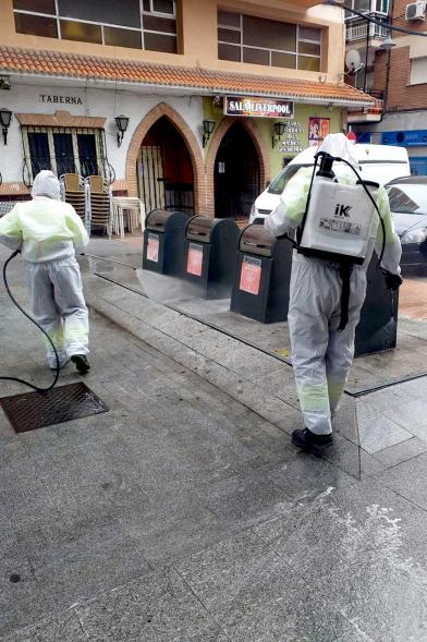 Operarios con traje de protección desinfectando las calles durante el confinamiento