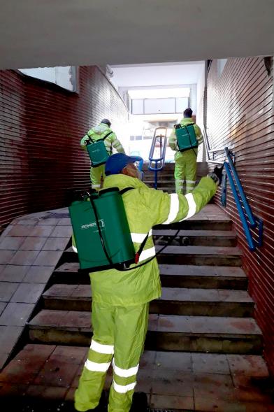 Operarios con traje de protección desinfectando las calles durante el confinamiento