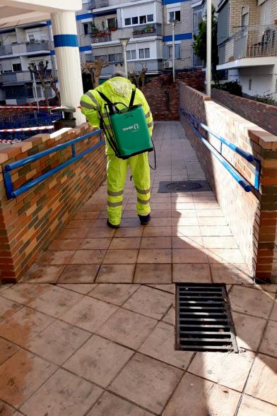 Operario con traje de protección desinfectando las calles durante el confinamiento
