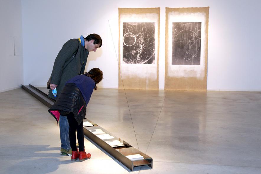 Inauguración Exposición "La Cámara de Niebla" de Linarejos Moreno - Dos visitantes observan una obra de suelo.
