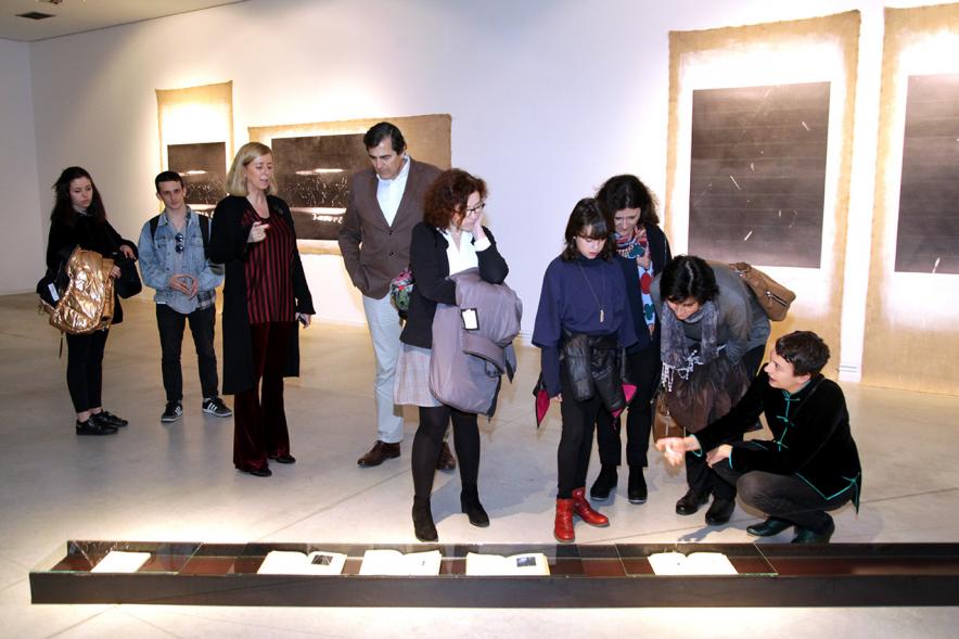 Inauguración Exposición "La Cámara de Niebla" de Linarejos Moreno - Los concejales y el publico observan una obra de suelo.