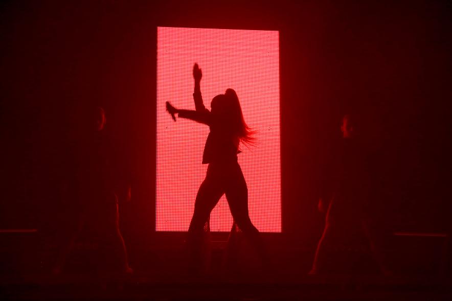Silueta de cantante sobre panel de luz roja