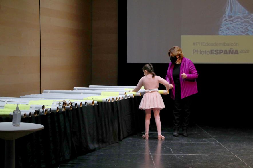 Entrega de Lonas Expo #PHEdesdemibalcon PHotoESPAÑA - Imagen de la concejala de cultura Rosario Tamayo junto a una niña en el momento de escoger la lona.